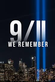 Memorial graphic with the text '9/11 WE REMEMBER' over a nighttime city skyline and the two bright vertical light towers.