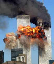 Twin towers with intense fire and smoke billowing out against a blue sky.
